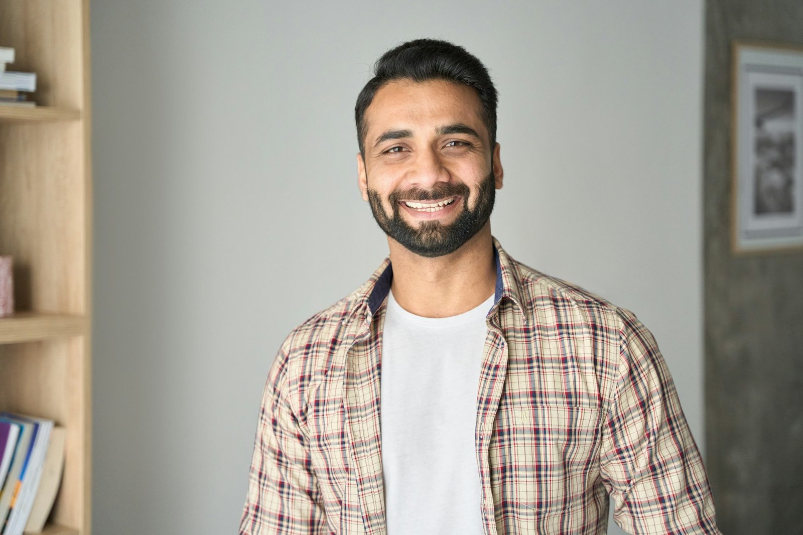 Headshot portrait of smiling attractive indian businessman indoors.